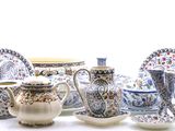 many different types of teapots and saucers on the table