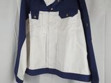 a white and blue jacket hanging on a white curtain