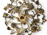 a gold plate with a bird and flowers on it