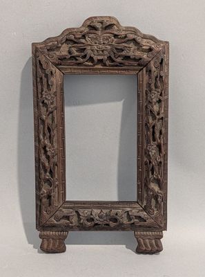 un vieux cadre en bois orné d'un motif sculpté
