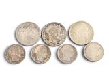 six different types of silver coins on a white surface