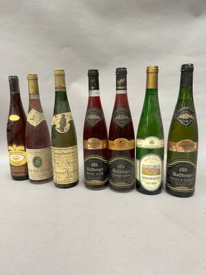 several bottles of wine are lined up on a white surface