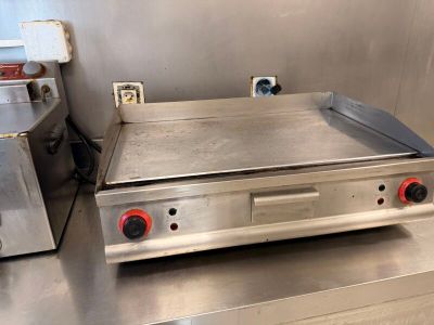 un plan de travail en acier inoxydable équipé d'une plaque de cuisson électrique et d'un grille-pain