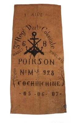 une vieille serviette marron sur laquelle sont représentés une ancre et une croix noires