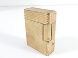a gold colored lighter sitting on a white surface