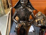 une statue représentant une femme tenant un chat sur une table