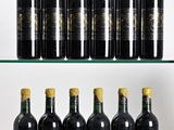 six bottles of wine are lined up on a glass shelf