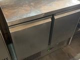 a stainless steel counter with two freezers and a roll of toilet paper on it