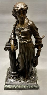statue en bronze représentant une femme tenant un panier et un couteau