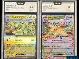 two pokemon cards in plastic cases on a black surface