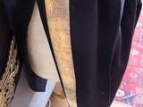 a mannequin wearing a black coat with gold trims