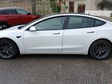 a white tesla model s parked in a parking lot