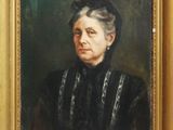 On y voit un tableau représentant une femme en robe noire, encadré dans un cadre doré.