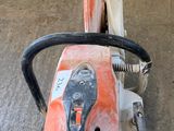 an orange and black chainsaw sitting on the floor