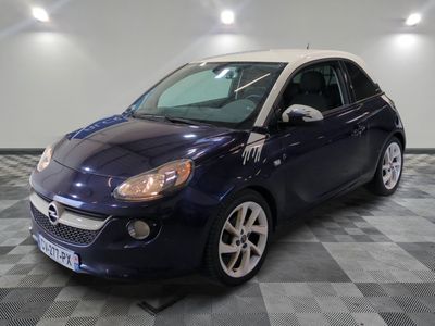 the small blue car is parked on a checkered tile floor