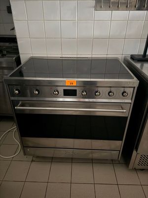 a stove and oven in a kitchen with tiled walls