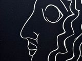a black and white drawing of a woman ' s face on a black background
