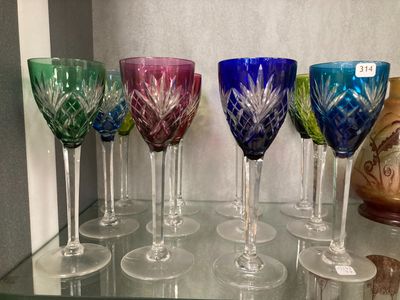 de nombreux verres à vin de différentes couleurs posés sur une étagère en verre