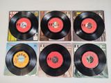 four black vinyl records with red and yellow labels on them