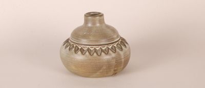 a small vase that is sitting on a white surface