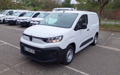 une camionnette blanche garée dans un parking à côté d'autres camionnettes