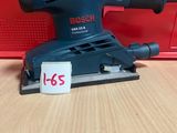 une ponceuse orbitale Bosch posée sur une table, avec une étiquette de prix