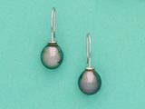 une paire de boucles d'oreilles en argent et perles noires sur fond turquoise