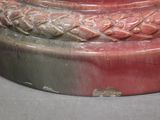 a close up of a red vase with a bird on it