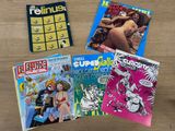 four comic books sitting on top of a wooden table