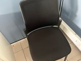 a black chair sitting in front of a blue wall