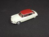 a toy car with a red roof on a black surface