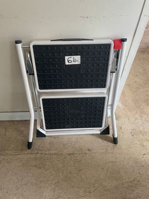 a black and white step stool next to a white wall