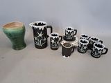 a lot of black and white vases and cups on the table