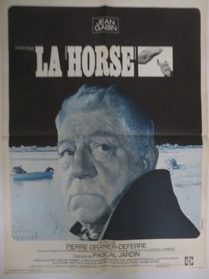 une vieille affiche de cinéma représentant un homme en manteau noir qui fixe l'objectif