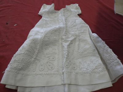 a white dress on a red cloth on a bed