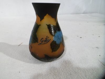 un petit vase posé sur une surface blanche