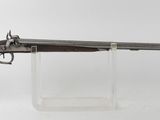 un gros plan d'un pistolet posé sur un socle, sur fond blanc