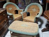 trois fauteuils en osier et un repose-pieds dans une pièce
