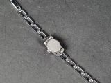 a close up of a watch on a metal bracelet on a table