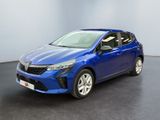 Une voiture bleue est garée dans une pièce au sol noir.