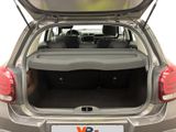 the back of a silver car with its trunk open and a license plate in the trunk