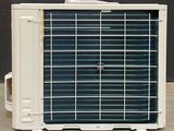 a air conditioner sitting on the floor in front of a black wall