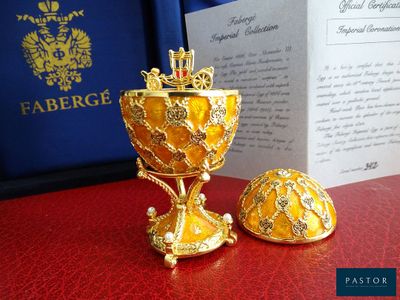un calice en or et un œuf en or posés sur une table rouge