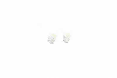 deux paires de boucles d'oreilles posées sur une surface blanche