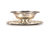 une assiette en argent sur laquelle est posée une soucoupe