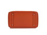 an orange purse with a metal handle on a white background