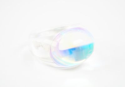une image représentant une bague sertie d'un verre aux couleurs de l'arc-en-ciel