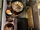 un récipient en métal rempli d'assiettes et de bols posé sur une table