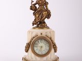 une petite horloge surmontée d'une statue