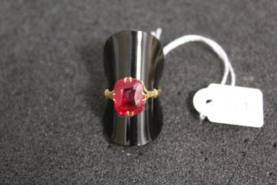 une bague sertie d'une pierre rouge et munie d'une étiquette de prix